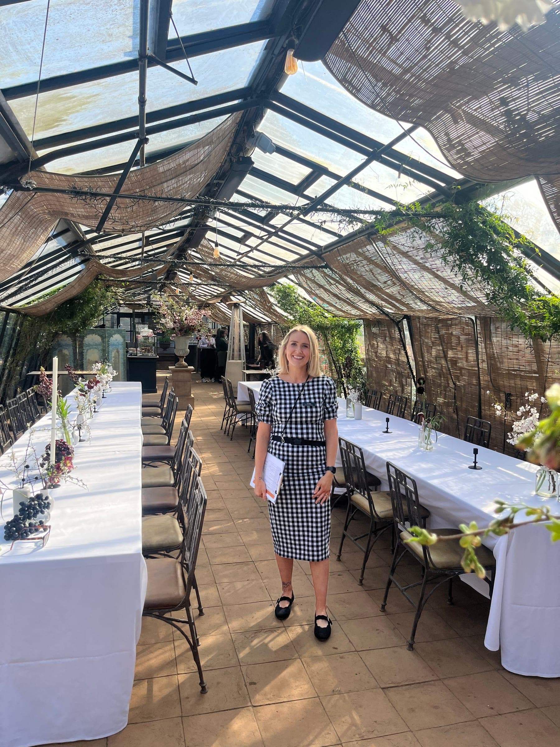 Tables being set in a glasshouse orangery